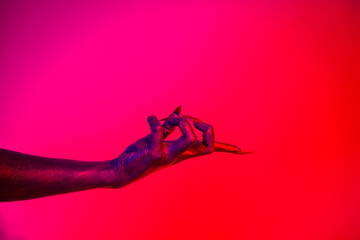 A witch hand with long nails appears against a red fire background, evoking a demonic, monstrous presence. Blending vampire, alien, ghost, and zombie elements, it perfectly embodies Halloween
