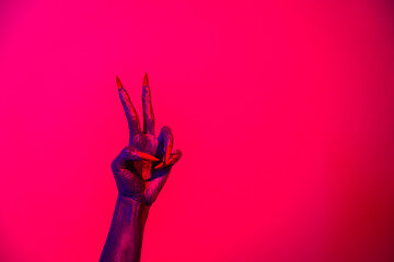 A witch hand with long nails appears against a red fire background, evoking a demonic, monstrous presence. Blending vampire, alien, ghost, and zombie elements, it perfectly embodies Halloween