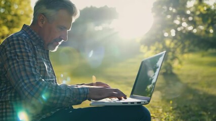 Man working on a laptop outdoors in sunlight, blending work and nature. The serene environment and glowing sun emphasize balance between productivity and relaxation.