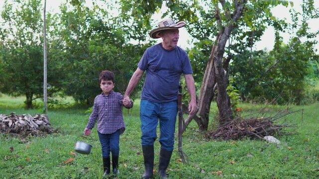 Ni&ntilde;o y su abuelo camino al cultivo de limones donde recolectan limones para hacer una limonada en familia.