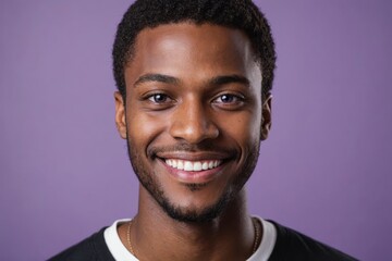 Obraz premium Full framed very close face portrait of a smiling young black man with violet eyes looking at the camera, studio shot,violet background.