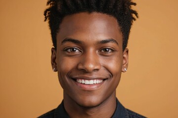 Obraz premium Full framed very close face portrait of a smiling young black non binary with amber eyes looking at the camera, studio shot,amber background.