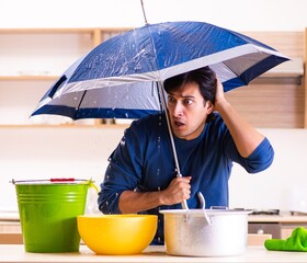 Young man in water leakage from the neighbors concept