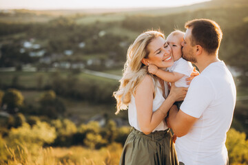 Happy Family Enjoying a Moment Together Outdoors in a Beautiful Landscape at Sunset