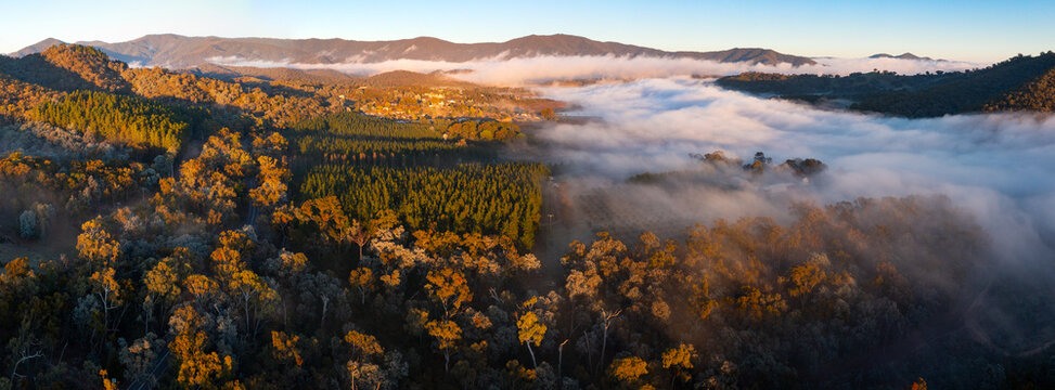 Aerial panorama of fog filling a valley below a distant mountain range