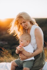 Mother and Baby Enjoying a Picnic at Sunset in a Peaceful Natural Setting