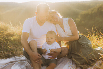 Young Family Enjoying a Sunny Day Outdoors with Their Baby in a Serene Natural Setting