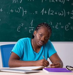 Black female student in front of chalkboard