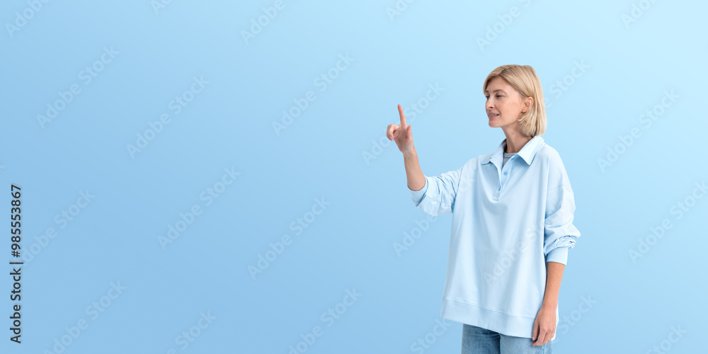 Wall mural young woman finger touch something on copy space background