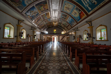 Fototapeta premium Interior of Bangar Church in Ilocos Sur, Philippines. Painting in the ceiling includes references to the power of the Holy Spirit, the body of the Virgin Mary, the finding of Jesus, and the temple