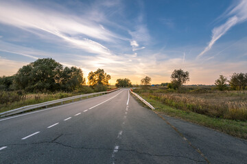 A road with a clear sky and trees in the background
