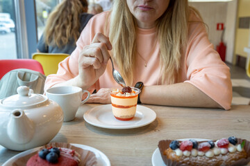 A woman is eating a dessert with a spoon