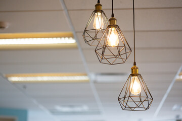 Three lighted lamps hanging from the ceiling