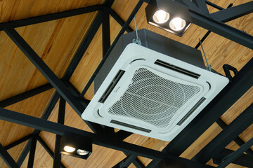 A white air conditioner is hanging from the ceiling