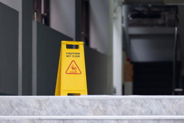 A yellow caution sign is on a floor