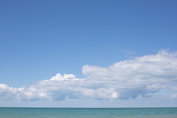 Blue sea and blue sky with white clouds. Seascape.