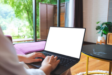 Fototapeta premium Mockup image of a woman using and typing on computer laptop with blank desktop screen at home