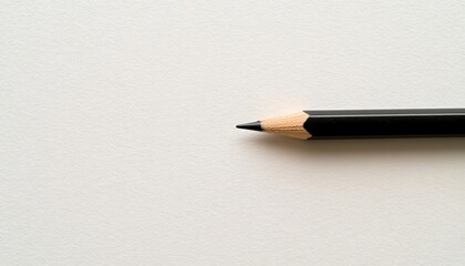A Black Pencil on a White Paper Surface