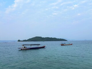 Obraz premium Bandar Lampung, Indonesia - September 1st 2024: Fishing boats are parked on the seashore in the afternoon with a cloudy sky in the background