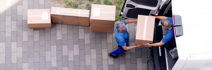 Movers carrying heavy boxes while moving