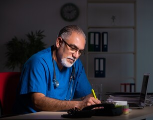 Aged male doctor in the hospital at night