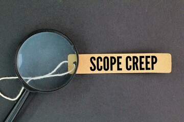 magnifying glass and a paper tag with the word Scope Creep. continuous or uncontrolled growth in a...