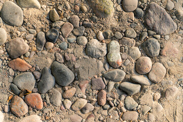 A close-up view of a gravel and pebble-strewn surface, showcasing a variety of natural textures, colors, and shapes. Ideal for backgrounds, abstract art, and design projects requiring an earthy look