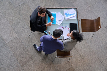 Aerial top view scene of group of business team working to  present new product of mainboard computer and informations on desk to create business plan.