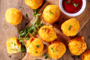 Top View of Crispy Fried Potato Balls with Ketchup – Delicious Snack on Wooden Background