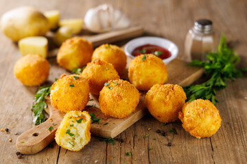 Deep Fried Potato Balls with Herbs and Ketchup – Tasty Snack on Wooden Background