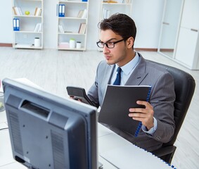 Businessman sitting in front of many screens
