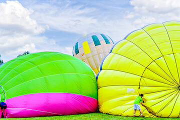 Colorful hot air balloon flying over blue sky with white clouds	