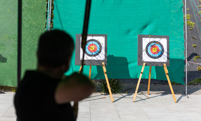 Archer shoots a bow at a target on a shooting range