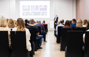 Rear view of the audience at a business conference meeting event listening to the speakers speech