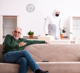 Young male sanitizer and old man indoors