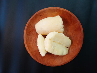 tape or tapai or peuyeum. cassava tape. tape or traditional Indonesian food made from fermented cassava served on a wooden plate on a black background.
