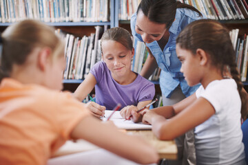 Exam, teacher and student with questions in a classroom or library for learning development. Education, kids and children asking help from woman with smile and support for assignment at school