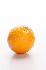 A single orange sits on a white background, showcasing its vibrant color and textured skin.