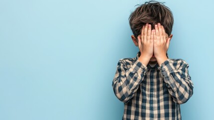 Young Boy Hiding His Face with His Hands