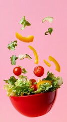 Vibrant salad ingredients dance in the air above a bright red bowl against a pastel pink backdrop