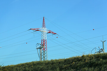 High-voltage poles with wires for transmitting electricity to populated areas.