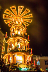 Traditional spinning  Christmas pyramid lit up at night, at Christmas market in Basel, Switzerland