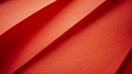 Red textured paper folded in geometric patterns, highlighting the material's structure and vibrant color