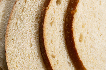 Freshly cut white sourdough bread on a wooden board. Delicious pastries for breakfast
