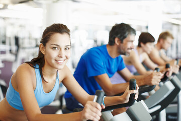 Portrait, spin class or happy woman in training, bike and exercise for gym, health or fitness....