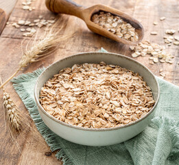 Bowl of wheat flakes on wooden table. Top view. Rural concept.