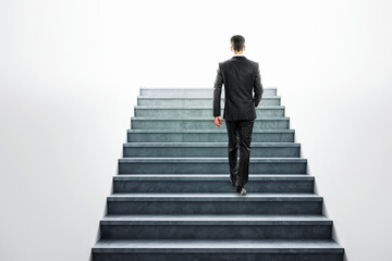 Businessman climbing a concrete staircase towards a bright future, symbolizing career advancement and success.