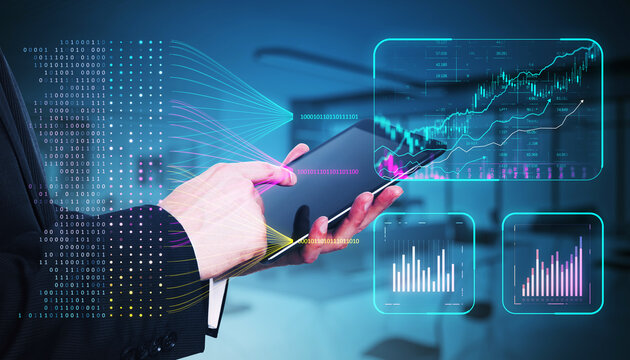 Businessperson using tablet with financial data charts and binary code holograms on screen in modern office.