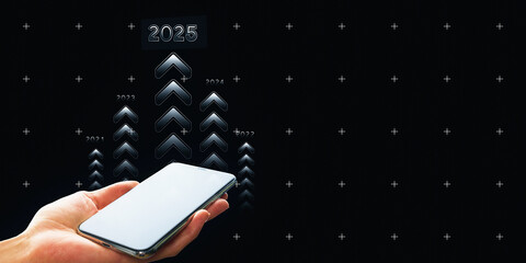 Hand holding a smartphone with upward arrows and year markers leading to 2025 on a dark background.