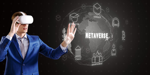 Man with VR headset interacting with metaverse holographic interface on black background.